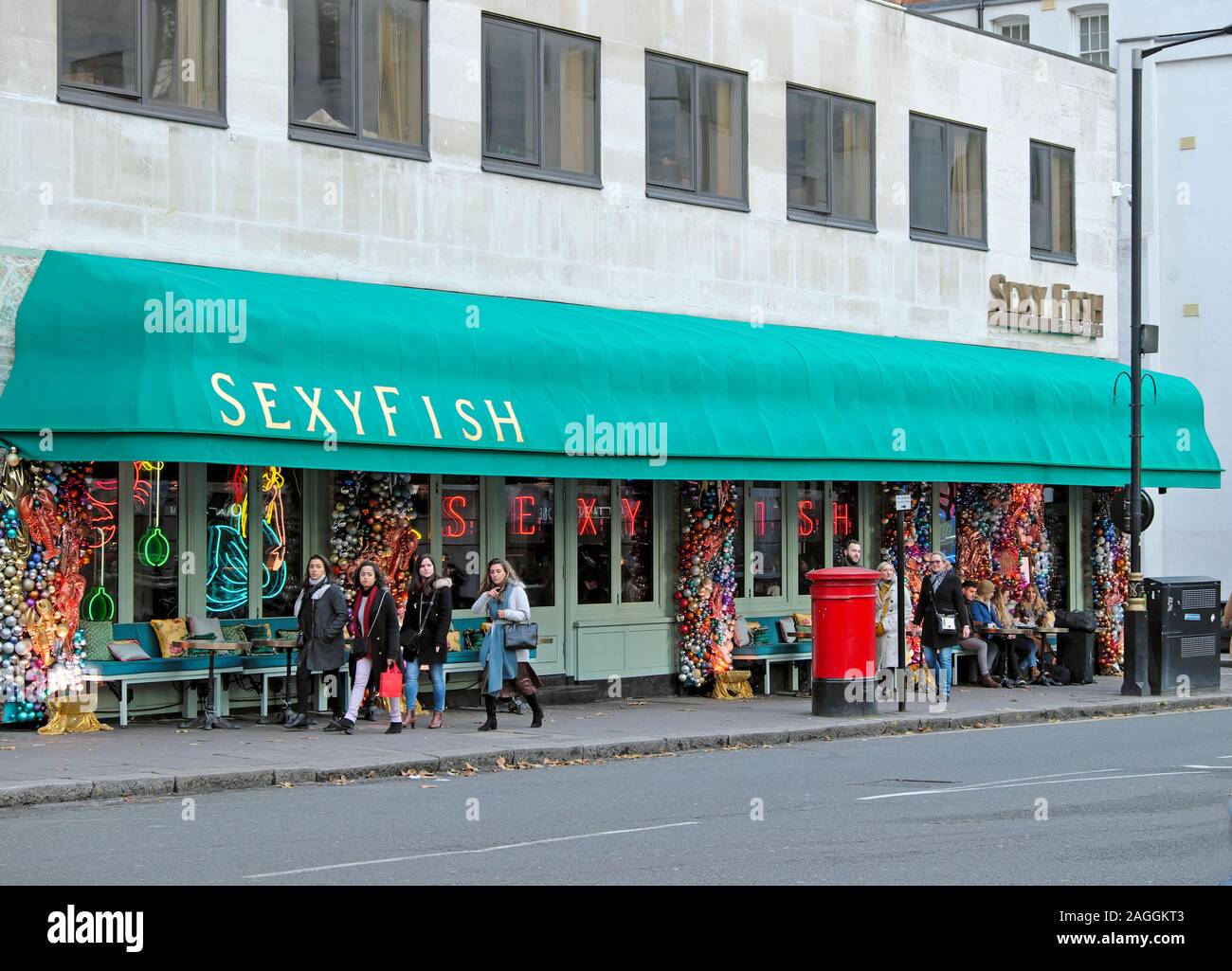 La gente a piedi in strada al di fuori Sexyfish ristorante esterno in Berkeley Square London W1 Inghilterra UK KATHY DEWITT Foto Stock