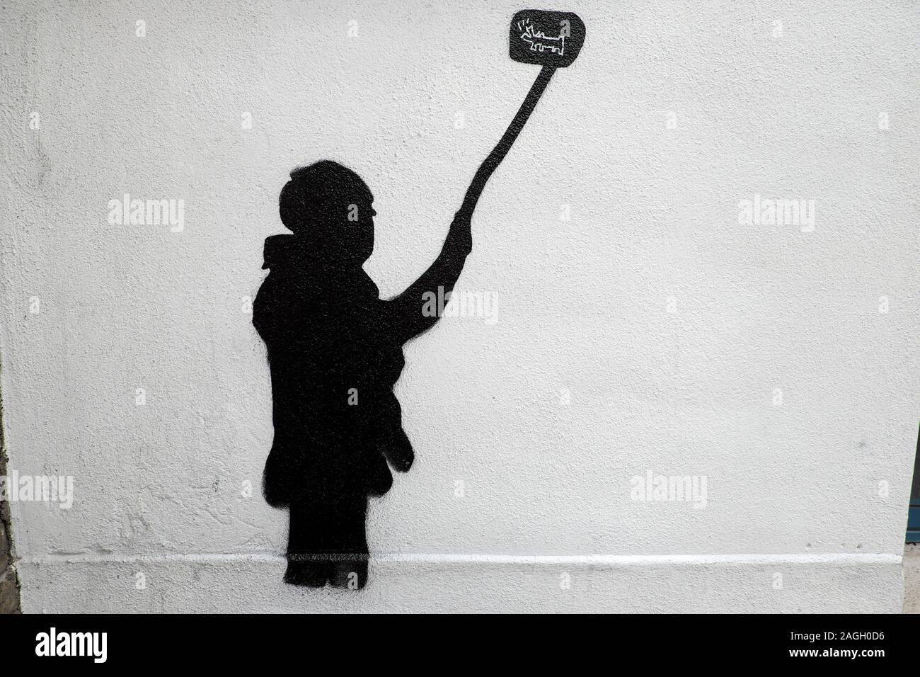 Street Art illustrazione silhouette di una persona in possesso di un bastone selfie prendendo una foto su un muro bianco in Londra England Regno Unito KATHY DEWITT Foto Stock