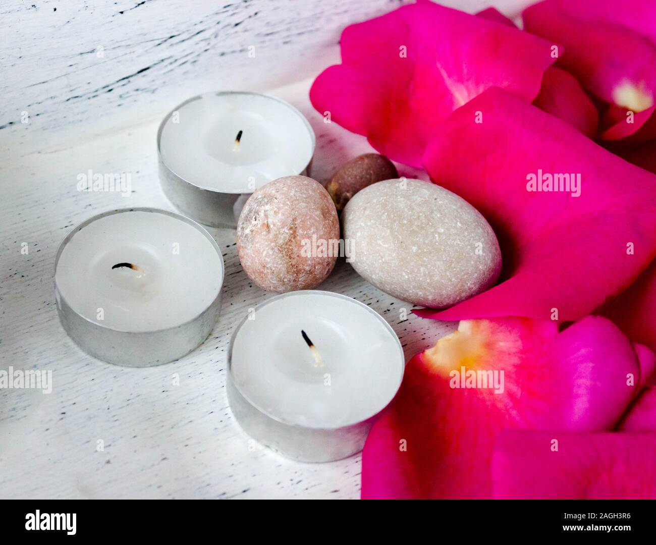 Pietre di Spa con rose e candele su tavolo di legno scuro, primo piano.  Festa di San Valentino Foto stock - Alamy