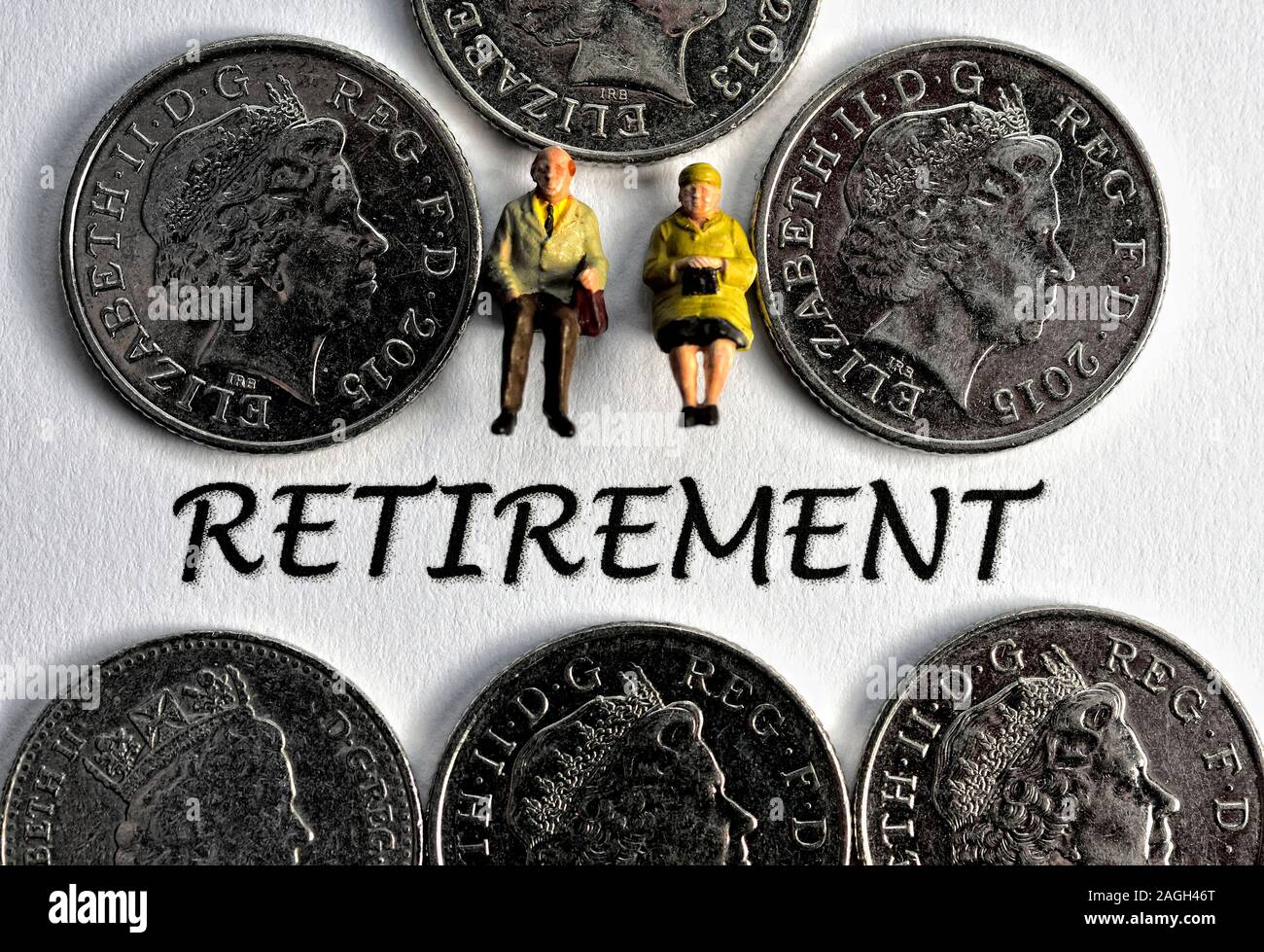 Due pensionati statuette in miniatura seduta al di sopra della parola Pensionamento Foto Stock