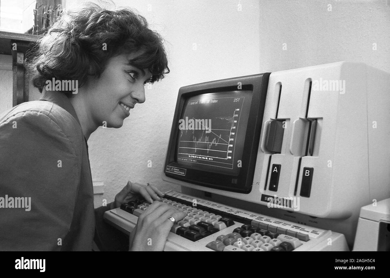 Anni ottanta, storico, lady lavoratore utilizzando un computer di ufficio, Inghilterra, Regno Unito. Foto Stock