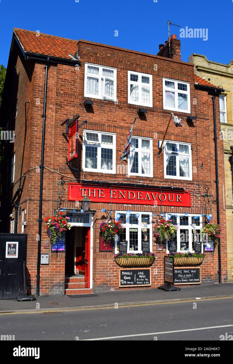 Il pub Endeavour, (precedentemente The Imperial) a Whitby, North Yorkshire, Inghilterra. (Come nel luglio 2017). Insegne offrono musica dal vivo, alloggio, camere, famiglia e cani, e 'portare il proprio patatine'. Foto Stock