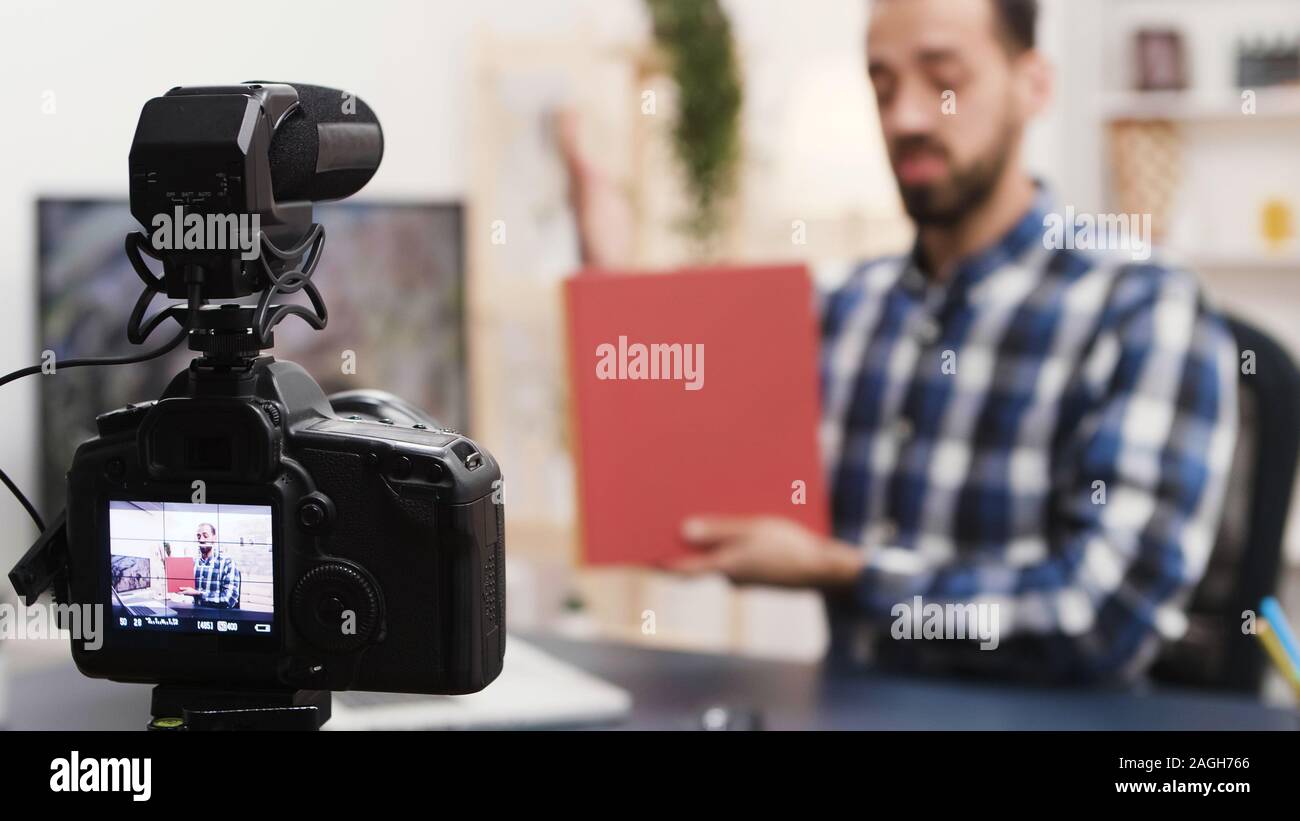 Creative giovane la registrazione di una recensione del libro per il suo social media. Famoso influencer. Foto Stock