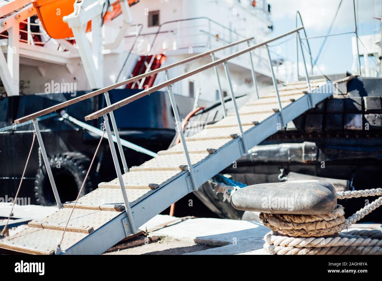 La nave è ormeggiata in un dock scaletta catena corda Foto Stock