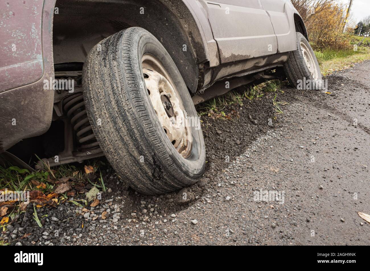 Una vettura in un incidente si trova in un fosso da strada rurale di giorno, close up photo ow ruota anteriore Foto Stock