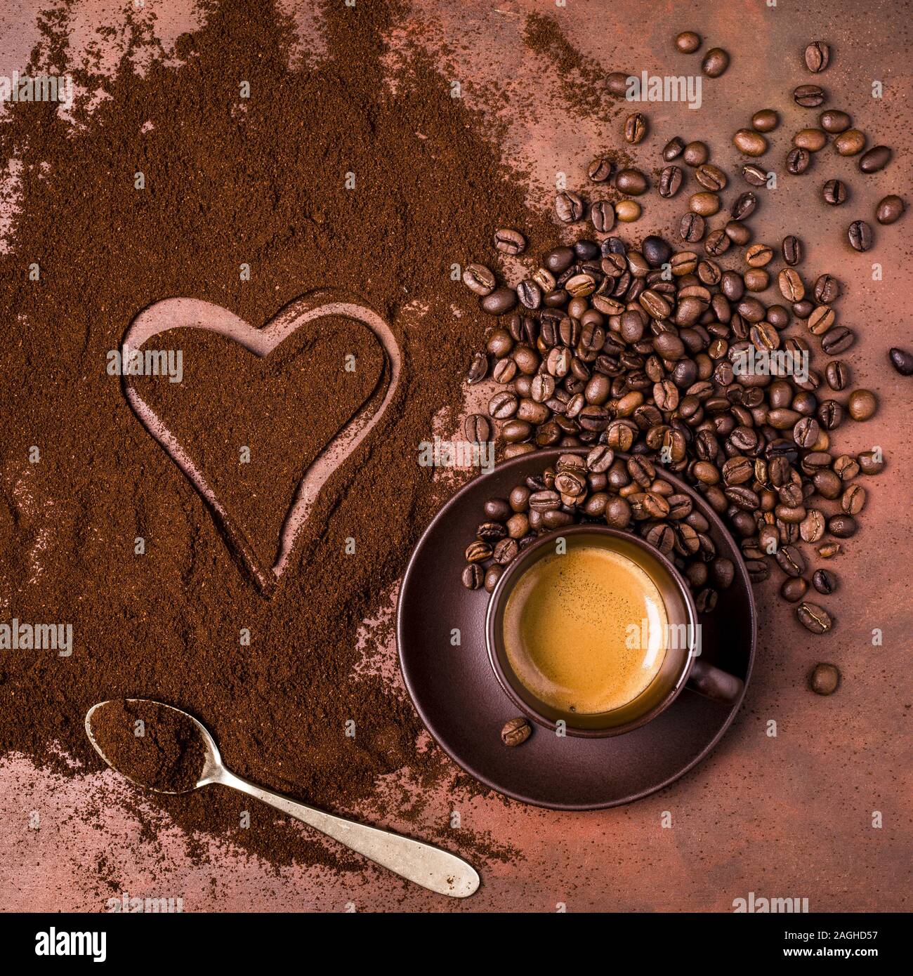 Una tazza di caffè espresso cremoso, una pila di caffè macinato con un  disegno di un cuore Foto stock - Alamy