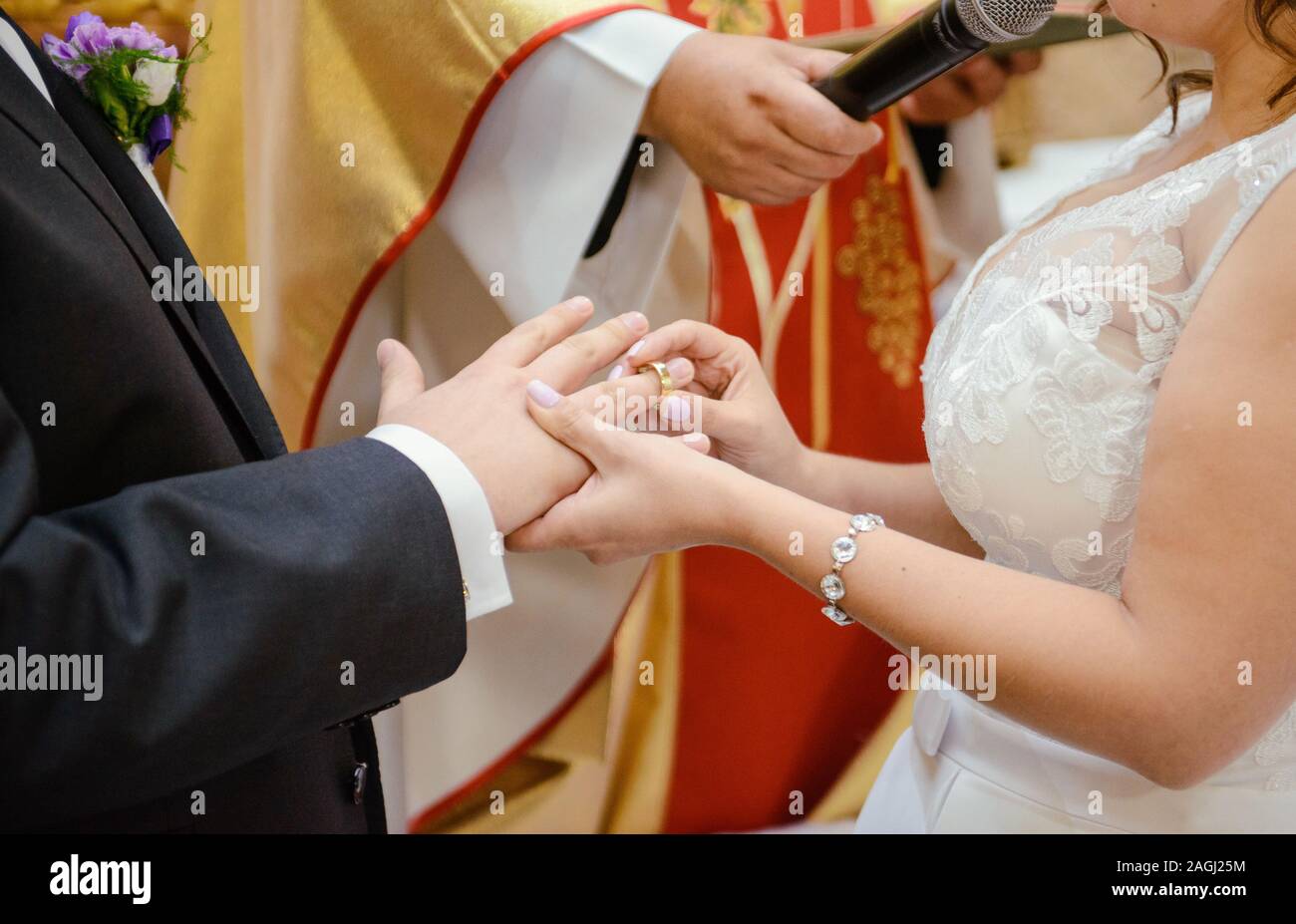 La sposa e lo sposo durante la cerimonia di nozze mettere gli anelli di nozze sulla loro dita. Foto Stock