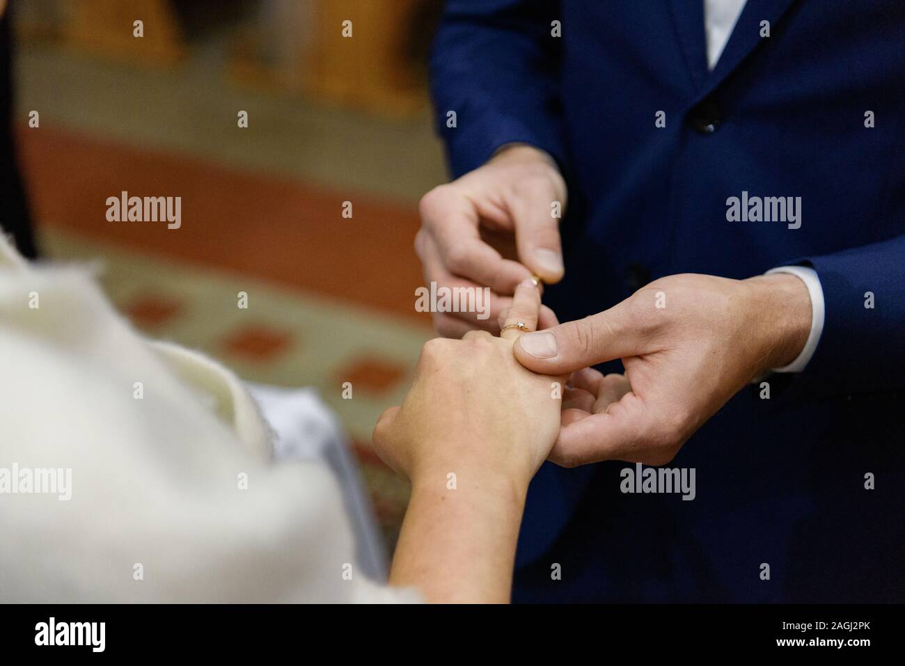 La sposa e lo sposo durante la cerimonia di nozze mettere gli anelli di nozze sulla loro dita. Foto Stock