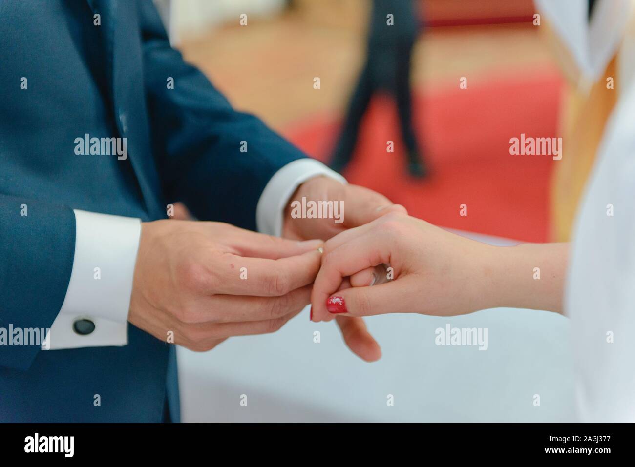 La sposa e lo sposo durante la cerimonia di nozze mettere gli anelli di nozze sulla loro dita. Foto Stock