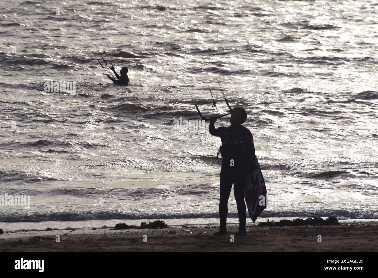 Exmouth kitesurf, Kitesurfer stagliano contro il Mare d'argento su un giorno inverni. Devon, Regno Unito Foto Stock