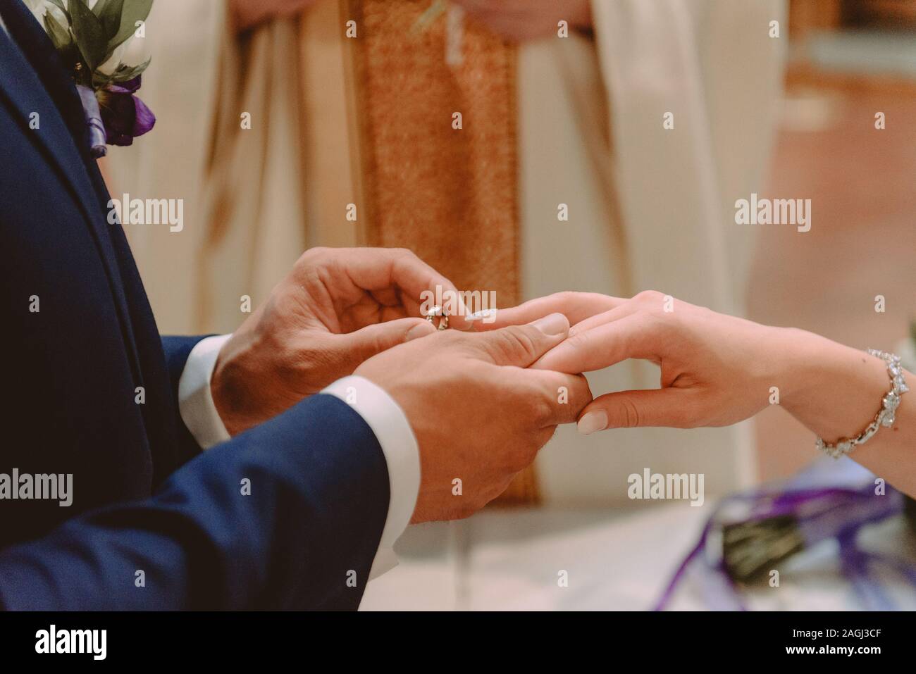 La sposa e lo sposo durante la cerimonia di nozze mettere gli anelli di nozze sulla loro dita. Foto Stock