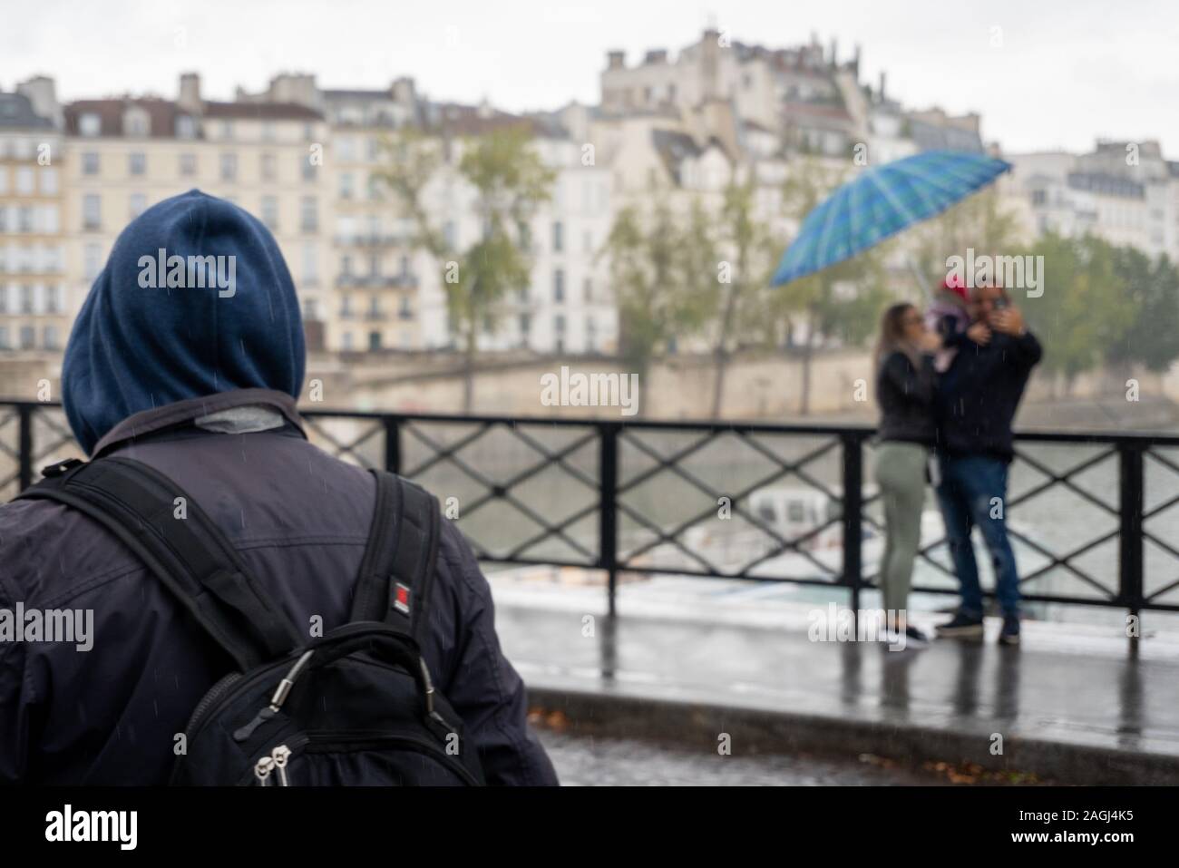 Persone sotto la pioggia su un ponte a Parigi Foto Stock