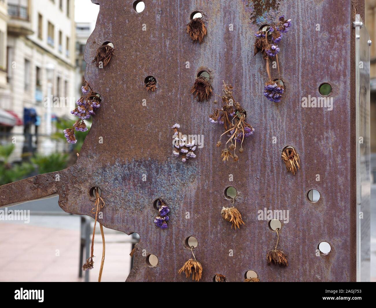 Patina di metallo ossidato Memorial Sculpture con secchi fiori eterni appesi da perforazioni a simboleggiare morto a San Sebastian,Spagna,l'Europa Foto Stock