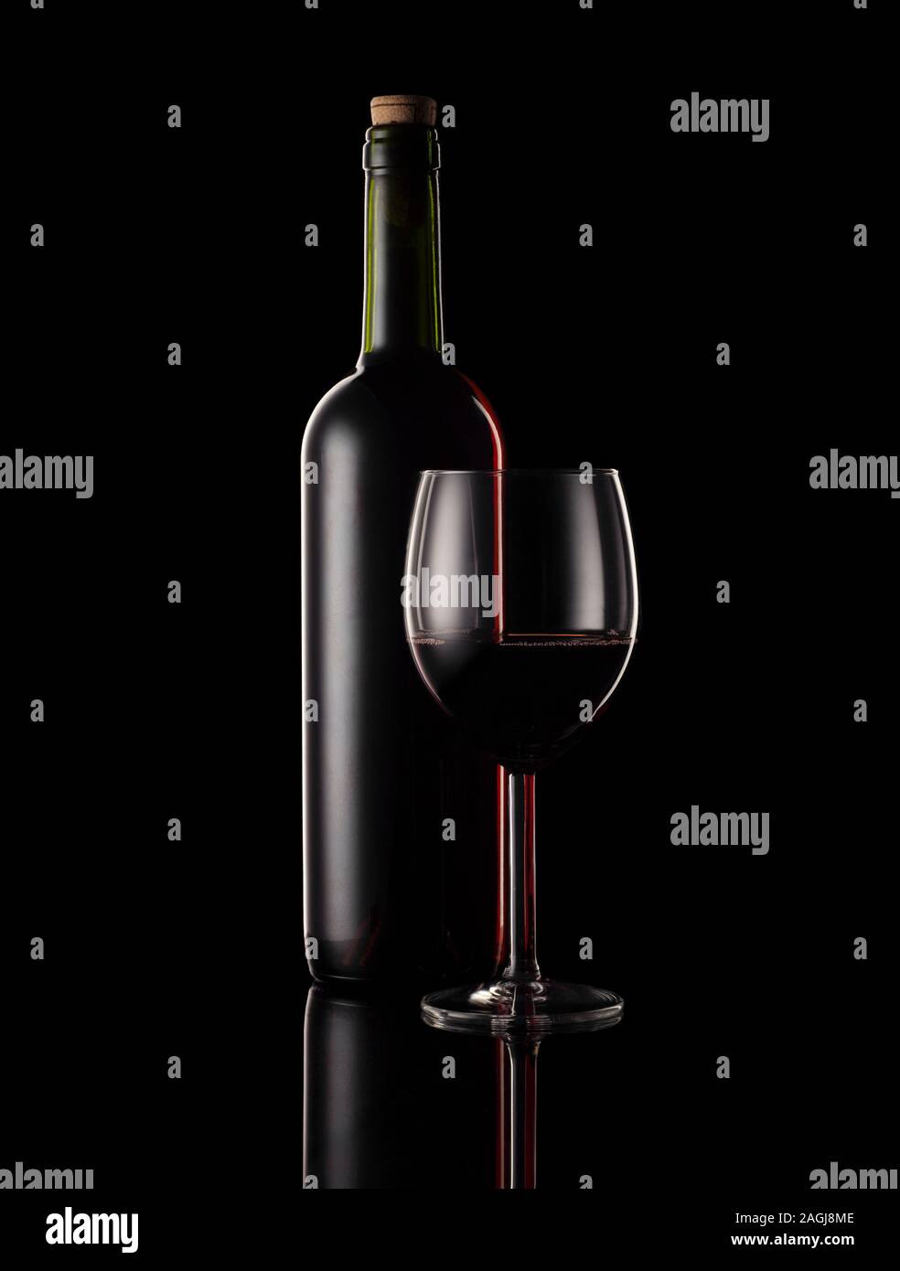 Rosso bottiglia di vino e il vetro con sfondo nero e illuminazione di RIM. Foto Stock