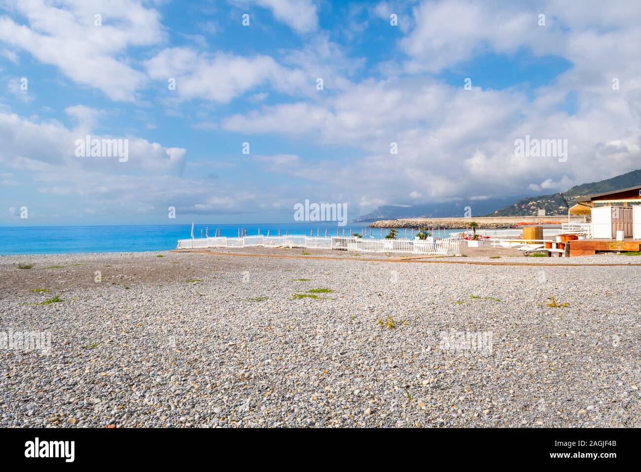 Il blu mare Mediterraneo, privato sulla spiaggia di ciottoli e la cittadina sul mare di Ventimiglia, Italia, sulla Riviera Italiana Foto Stock