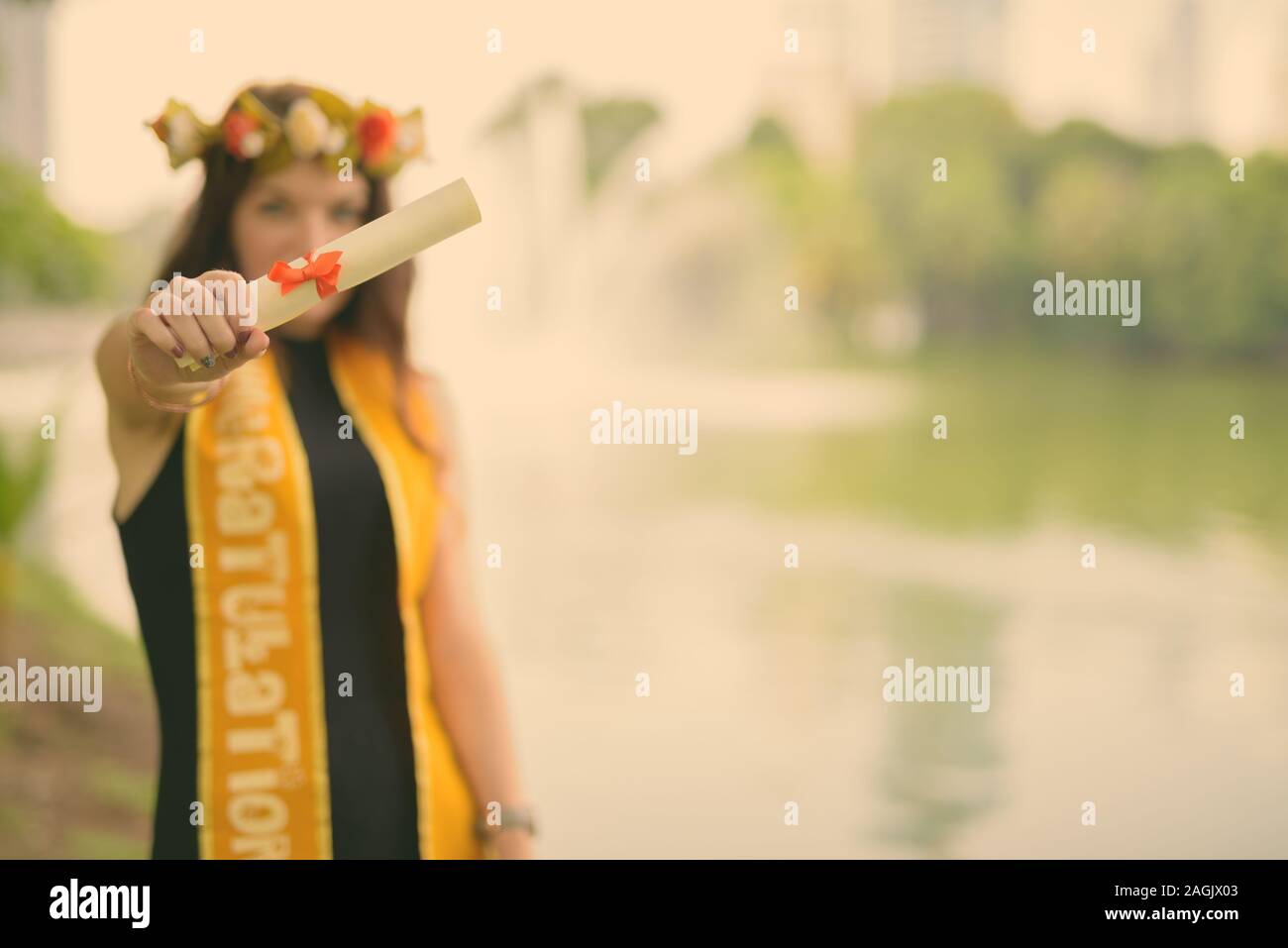 Giovane bella donna celebrando la laurea presso il parco a Bangkok, in Thailandia Foto Stock