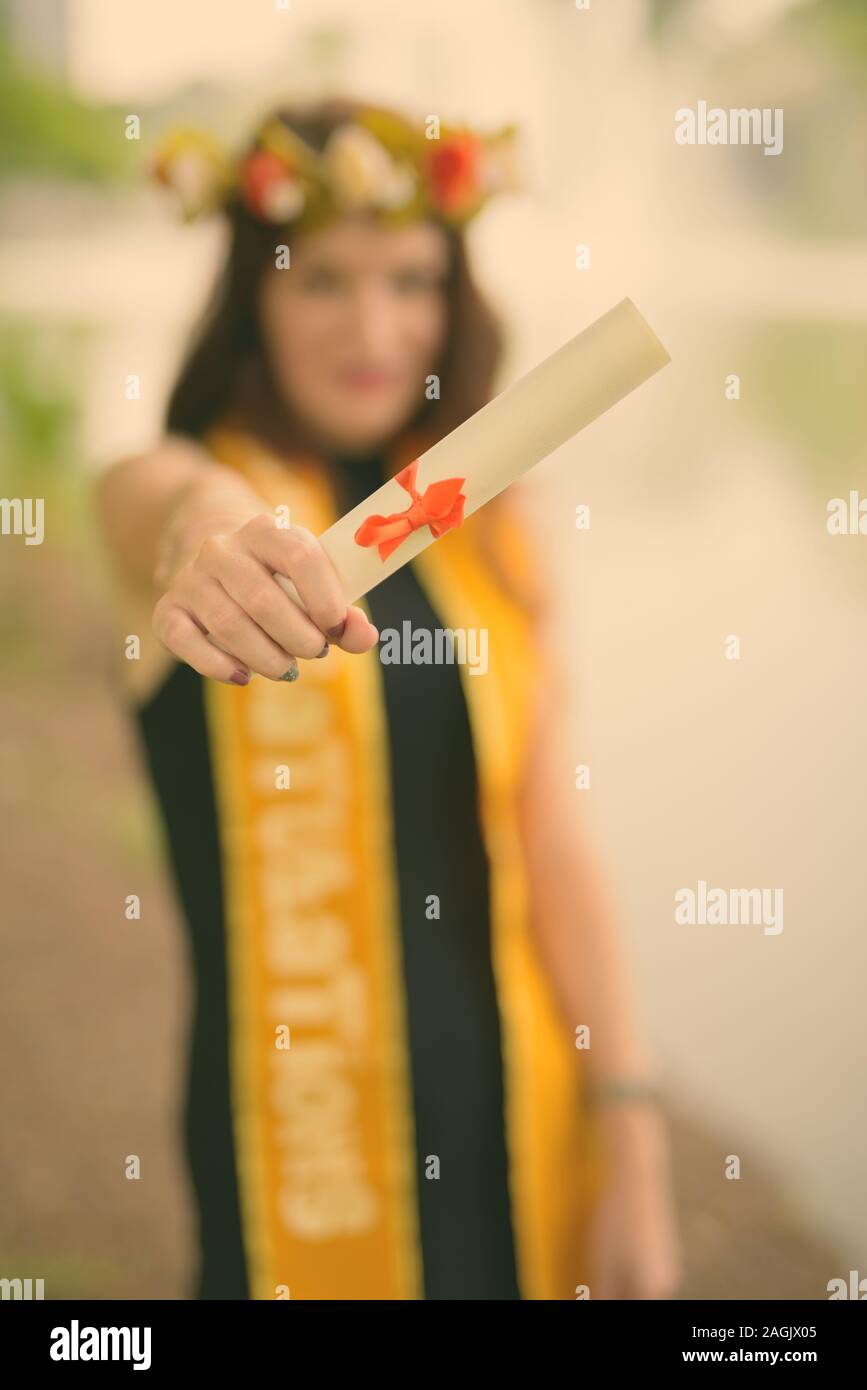 Giovane bella donna celebrando la laurea presso il parco a Bangkok, in Thailandia Foto Stock