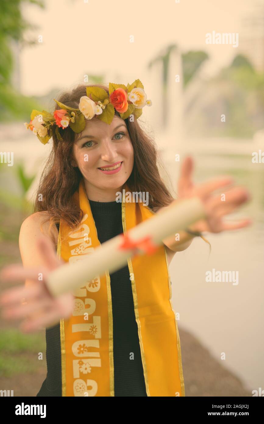 Giovane bella donna celebrando la laurea presso il parco a Bangkok, in Thailandia Foto Stock