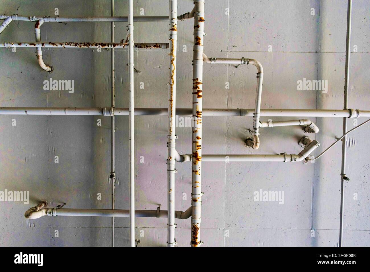 Metallo sistema di tubazioni e tubi dell'acqua sul soffitto in cemento. Rusty perde la pipeline e il plumbing labirinto dipinto sul soffitto in cemento. Foto Stock