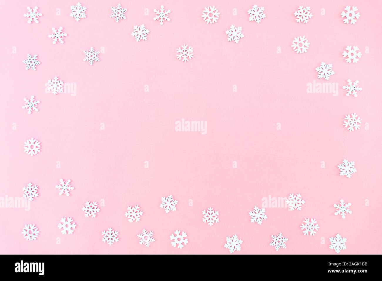 Composizione di natale. Il Natale di fiocchi di neve su sfondo rosa. Appartamento laico, vista dall'alto, spazio di copia Foto Stock