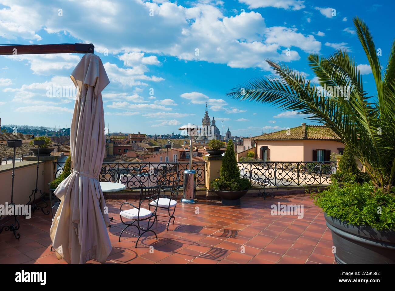 Terrazza con palme e vista sul tetto e con il campanile della chiesa di Roma in Italia. Foto Stock Terrazza con palme e vista sul tetto e con il campanile della chiesa di Roma in Italia. Foto Stock