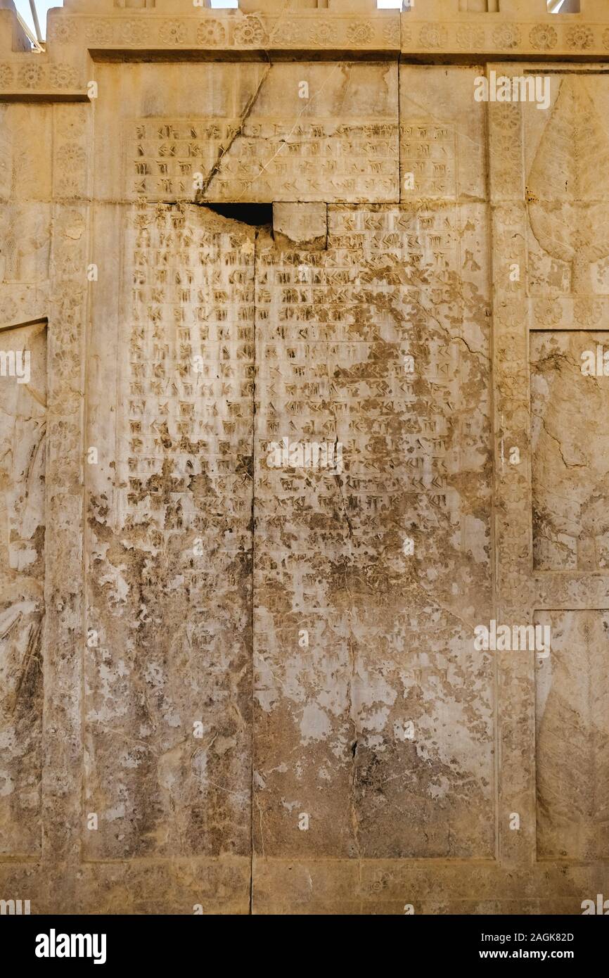 Rovine antiche vecchie scrittura cuneiforme persiana stone iscrizione ai corsi di lingua sumera a Apadana scale in antica dimora storica Persepolis, Iran. Foto Stock