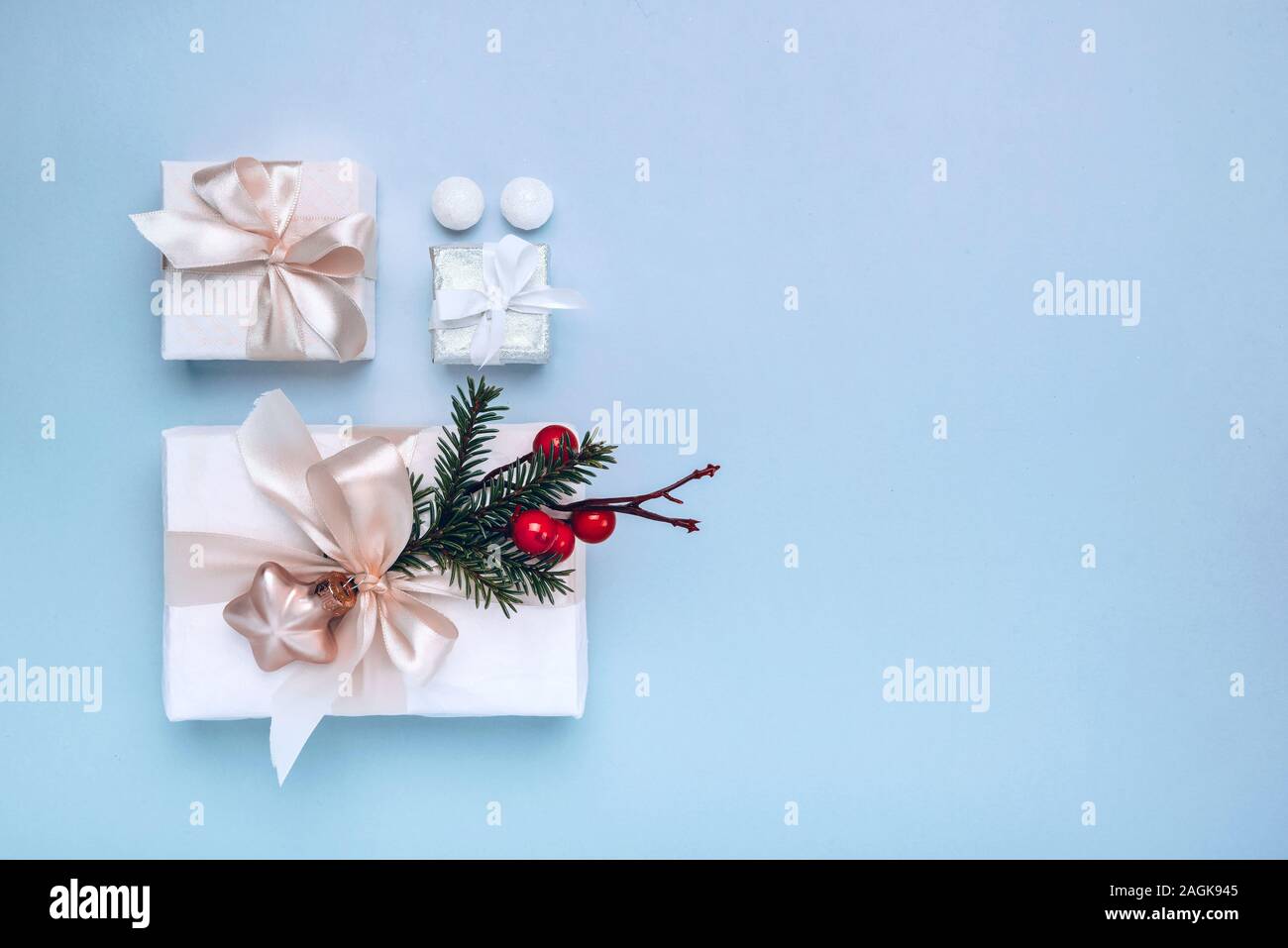 Doni con decorazioni di Natale nelle caselle bianche su sfondo blu. Il minimalismo, piatto di laici che, vista dall'alto, spazio di copia Foto Stock