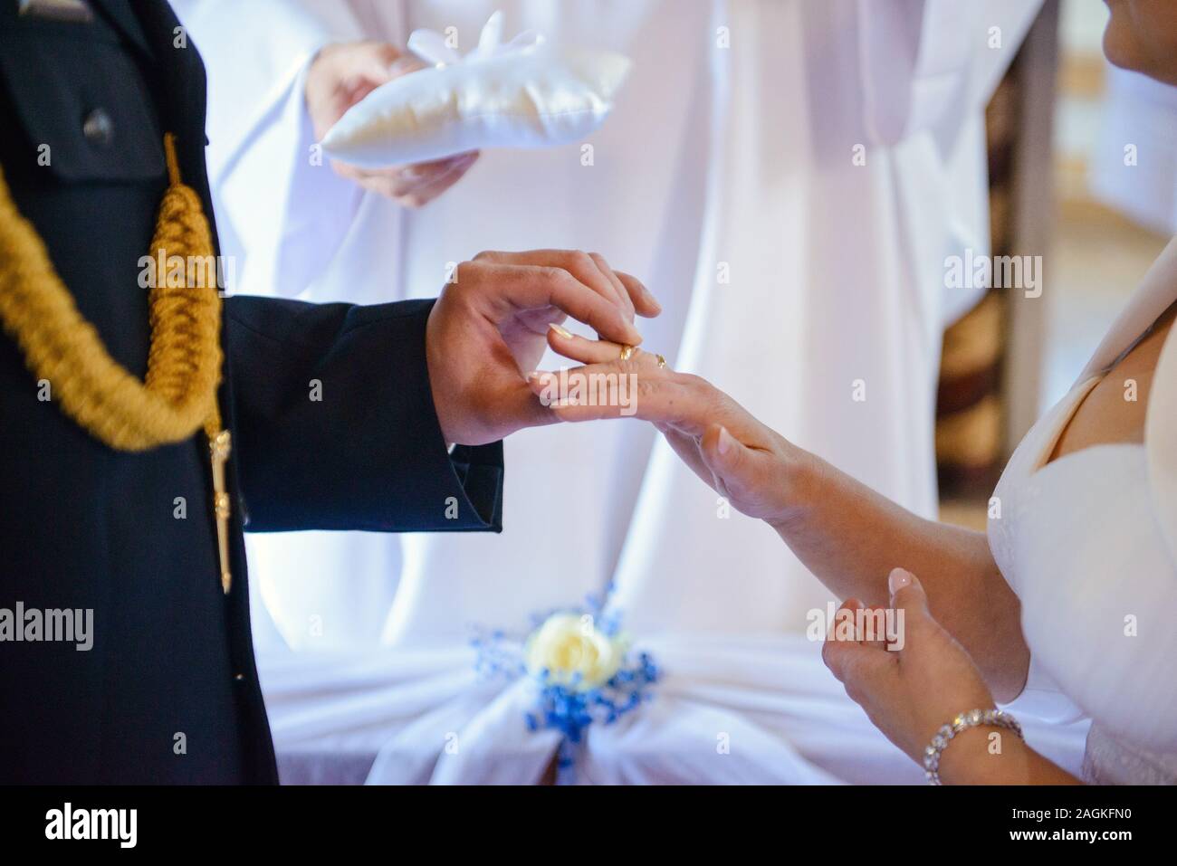 La sposa e lo sposo durante la cerimonia di nozze mettere gli anelli di nozze sulla loro dita. Foto Stock