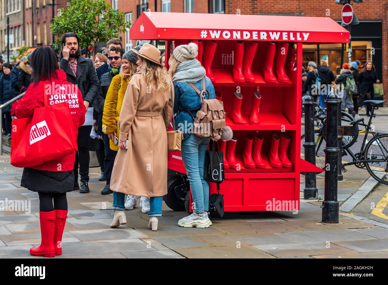Fitflop Wonderwelly della promozione nella zona londinese di Spitalfields Market. Wonderwelly è promosso come super confortevoli stivali da pioggia. Foto Stock