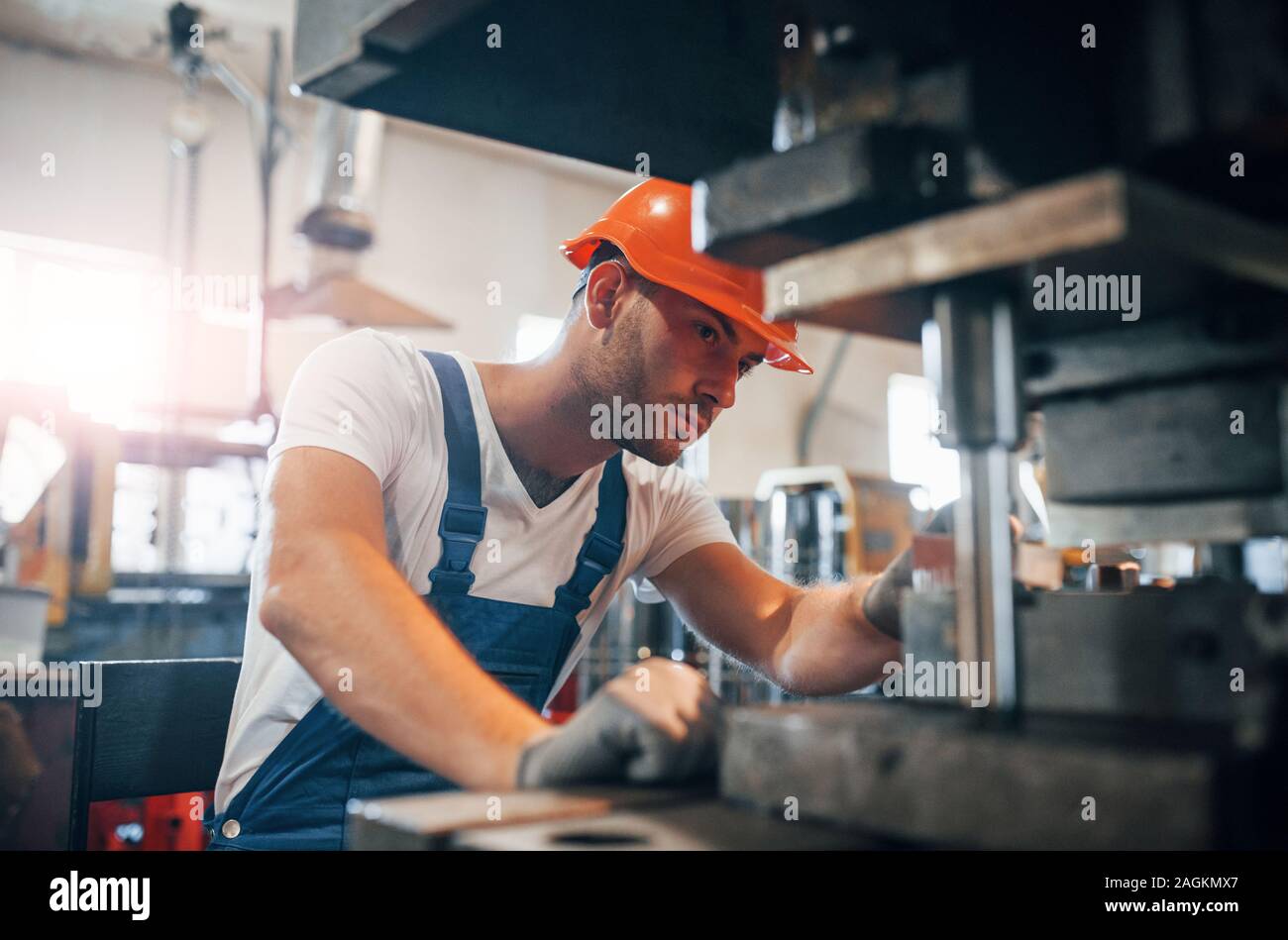 Look concentrato. Uomo in uniforme lavora sulla produzione. Industriale la tecnologia moderna Foto Stock