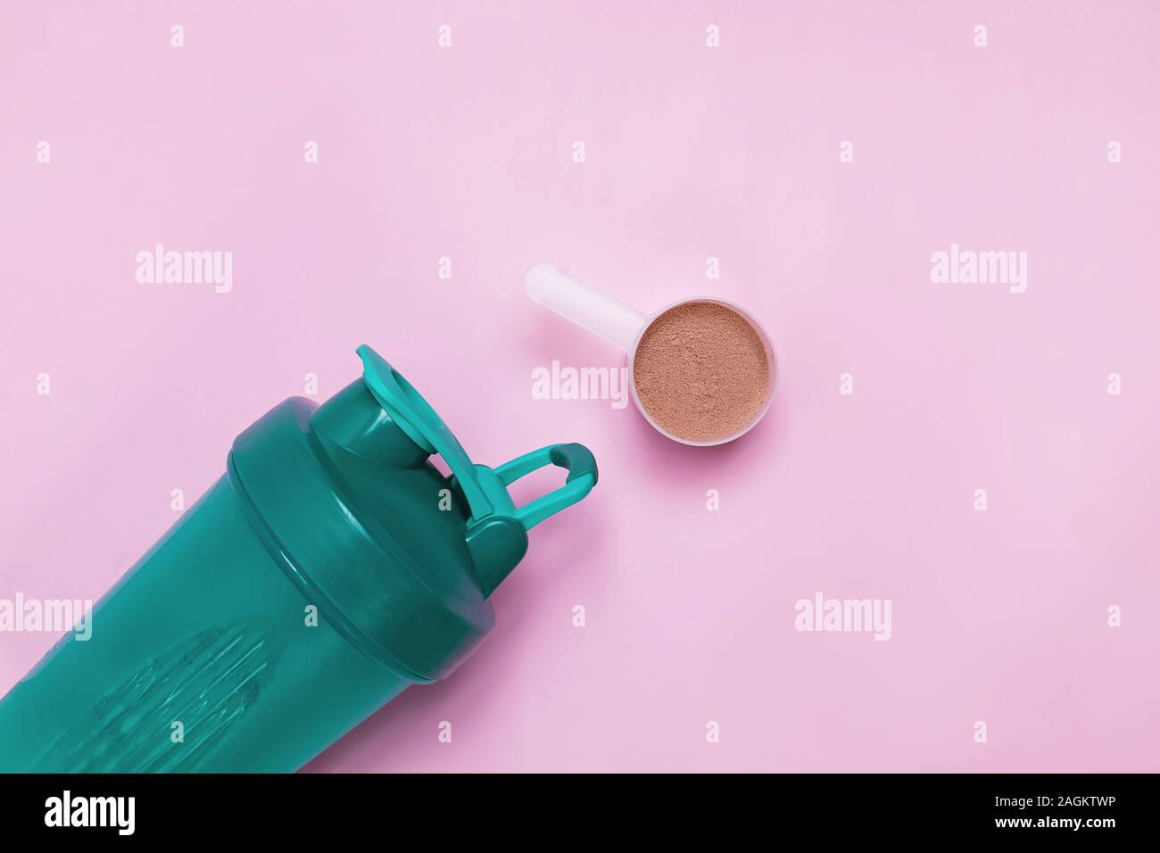 Shaker di proteine e cioccolato scoopon porein su sfondo rosa, Foto Stock