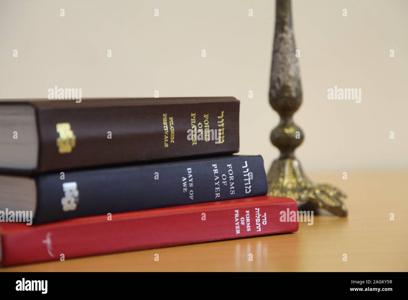 Preghiera ebraica Libri impilati sul tavolo con il menorah in background Foto Stock