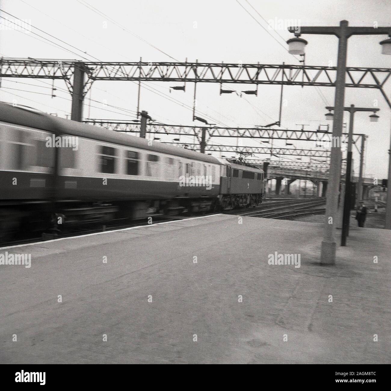 Anni Settanta, storici British Railways treno attraversa una stazione ferroviaria in velocità, Inghilterra, Regno Unito. Foto Stock