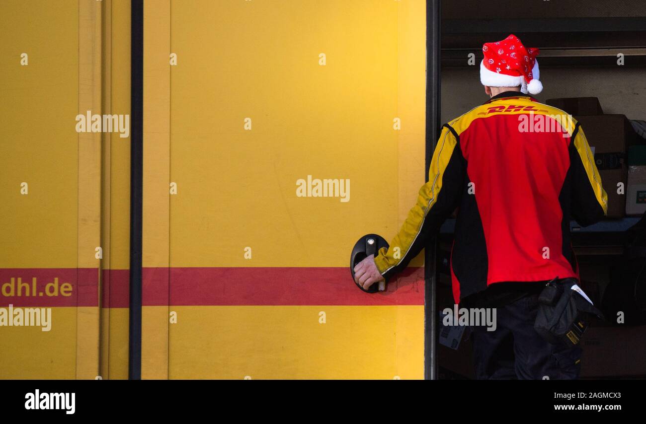 Wolfsburg, Germania. Xx Dec, 2019. A Deutsche Post DHL parcel liberatore  indossa un Babbo Natale cappello a lavoro. Circa 25.000 consegne  complementari effettuate saranno utilizzati per la stagione di Natale da  aziende
