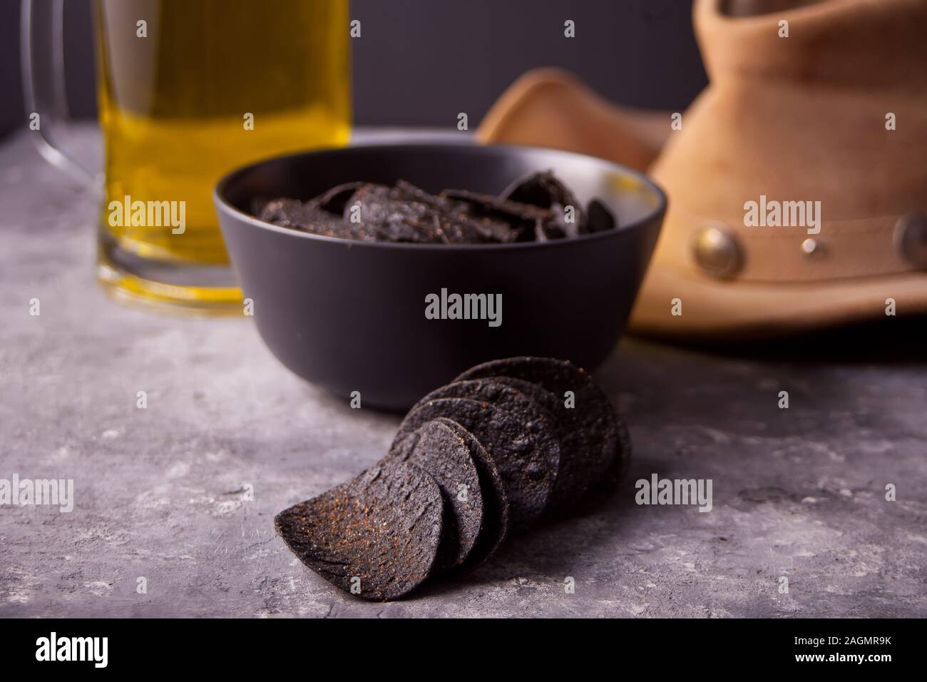 Mais messicano chips nachos, bicchiere di birra e il cappello da cowboy. Chip nero nachos per uomini brutali Foto Stock