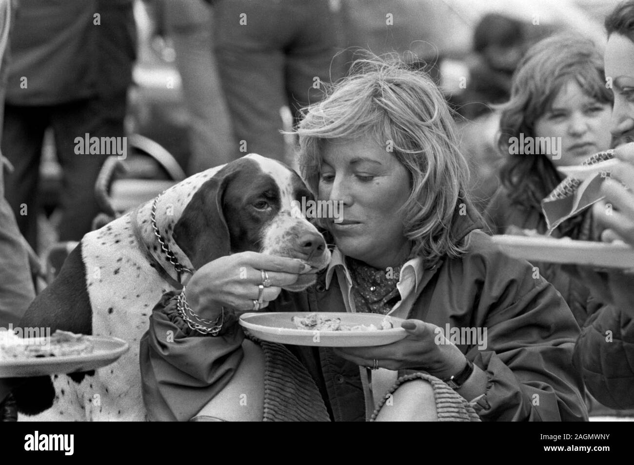 Alimentazione cane animale domestico che è dato un trattamento. Cibo umano condiviso con gli animali domestici anni '80. Gli ospiti del Cowdray Park Polo Club 1981 persone britanniche amano i loro cani da compagnia. REGNO UNITO HOMER SYKES Foto Stock