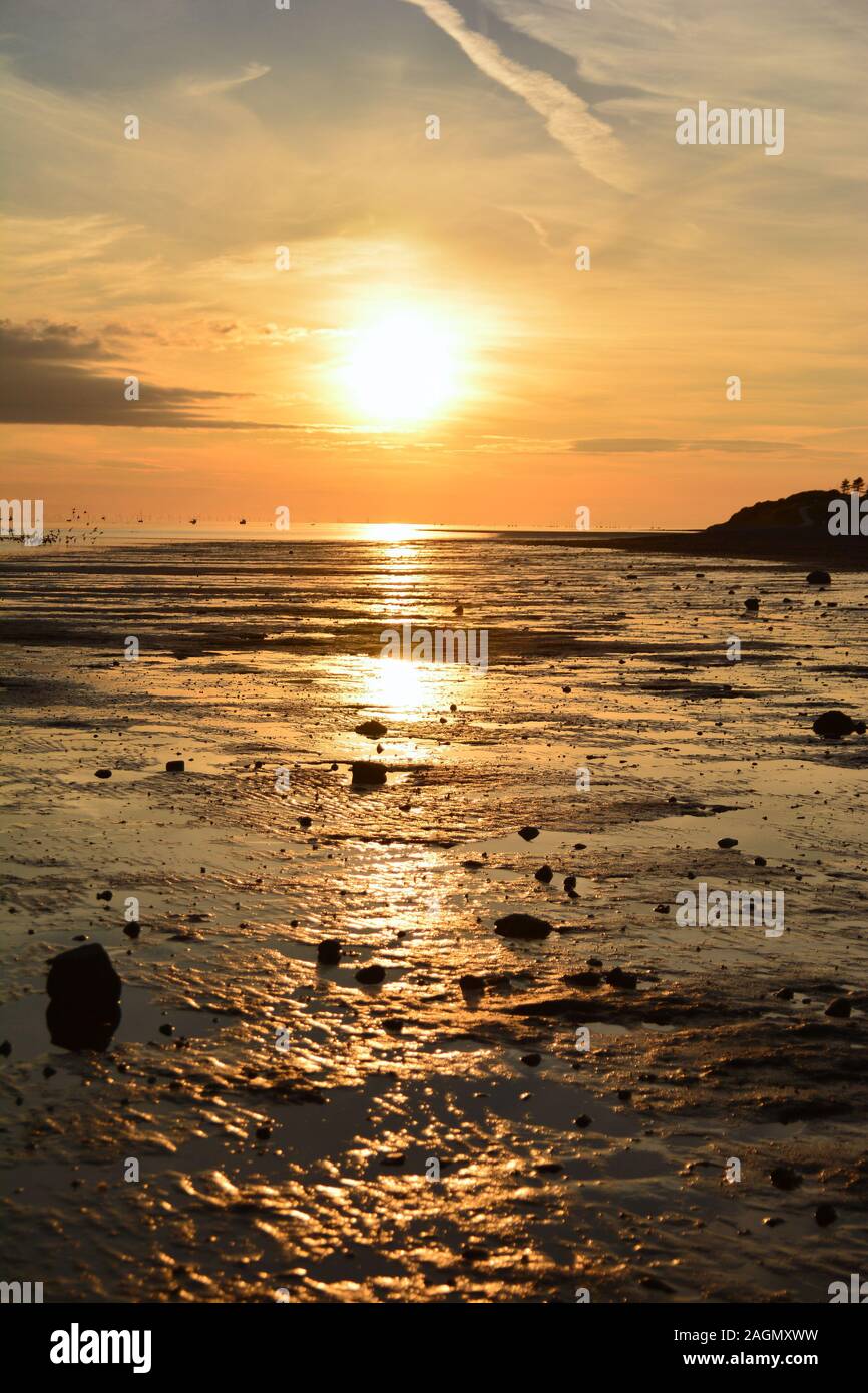 Una fotografia di un tramonto sulla costa a bassa marea in estate nel Regno Unito Foto Stock