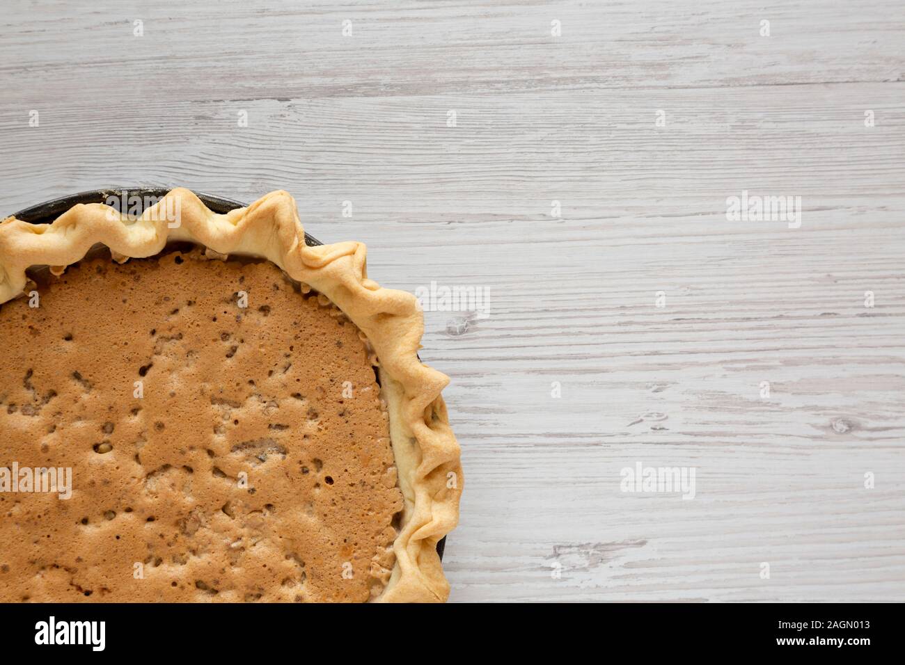 Vista superiore, cioccolato artigianale in legno di noce torta Derby su un bianco superficie di legno. Da sopra, overhead, piatto laici. Spazio per il testo. Foto Stock