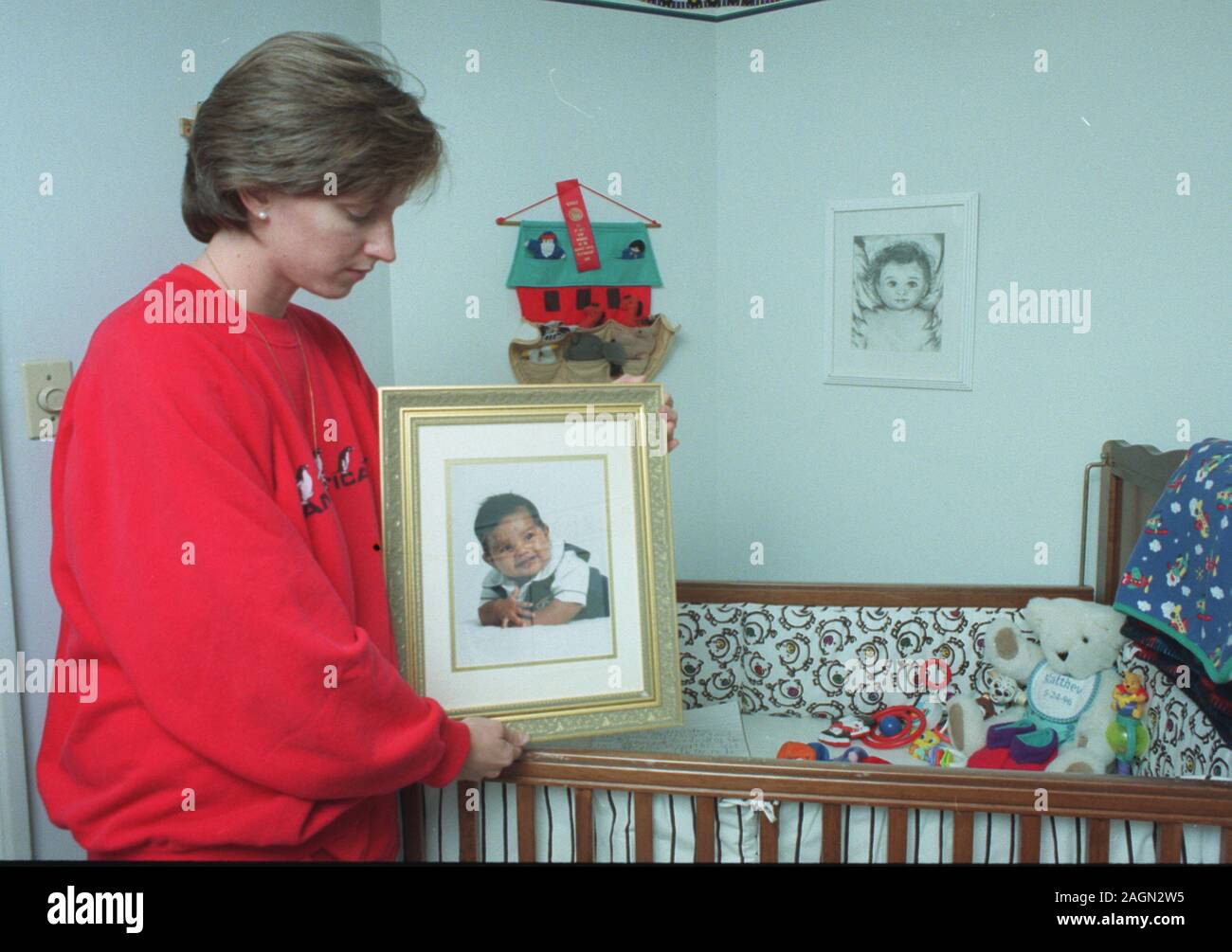 Deborah Eappen sorge accanto al suo figlio morto di Matteo presepe tenendo un ritratto di lui nella sua camera da letto in casa loro a Newton., ma Nov 1997 foto esclusive di Bill Belknap Foto Stock