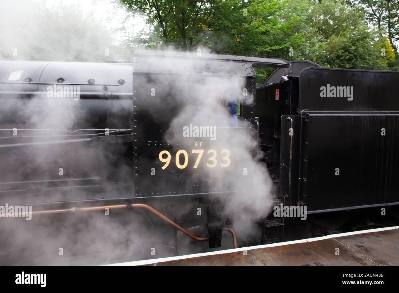 Dipartimento di guerra austerità 2-8-0 merci pesanti locomotiva a vapore n. 90733 avvolto in vapore durante l'attesa in stazione Oxenhope, Yorkshire R.U. Foto Stock