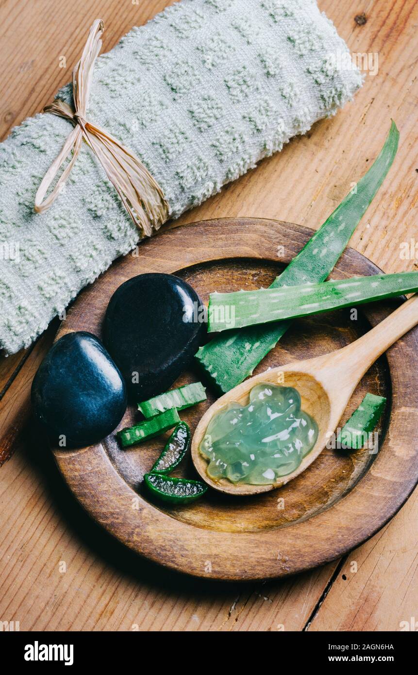 Vista dall'alto di aloe vera spa e wellness prodotto cosmetico per la cura della pelle e la bellezza. Naturali a base di erbe aromaterapia e massaggi zen pietre sul legno vintage Foto Stock
