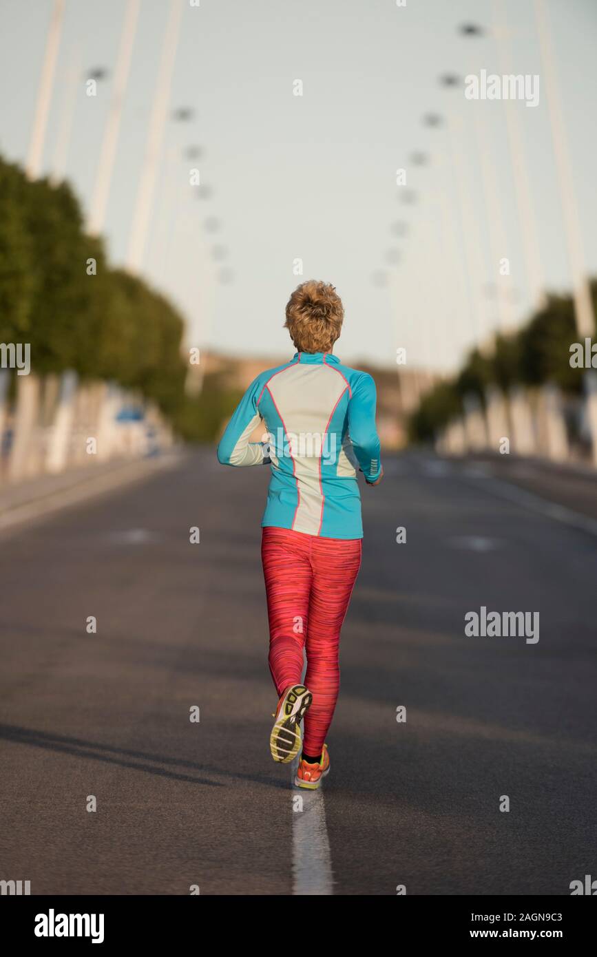 Femminile correndo giù per strada urbana, Alicante, Spagna, Europa Foto Stock