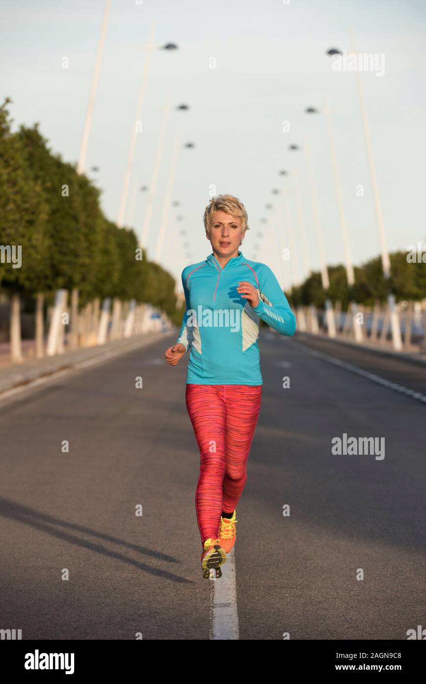 Femminile correndo giù per strada urbana, Alicante, Spagna, Europa Foto Stock