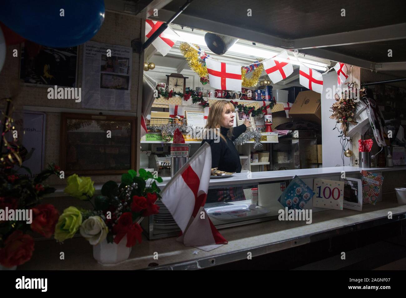 Londra, Regno Unito. 20 dicembre, 2019. Cheryl punti di diamante ad una fotografia di Syd Tothill mentre si prepara a chiudere Syd's Coffee stallo per l'ultima volta. Il caffè in mogano stallo, parte della zona est di Londra di storia, è stata gestita da tre generazioni della stessa famiglia all'angolo di Shoreditch High Street e Calvert Avenue dal 1919 e andrà sul display nel nuovo museo di Londra in Smithfield nel 2024. Credito: Mark Kerrison/Alamy Live News Foto Stock