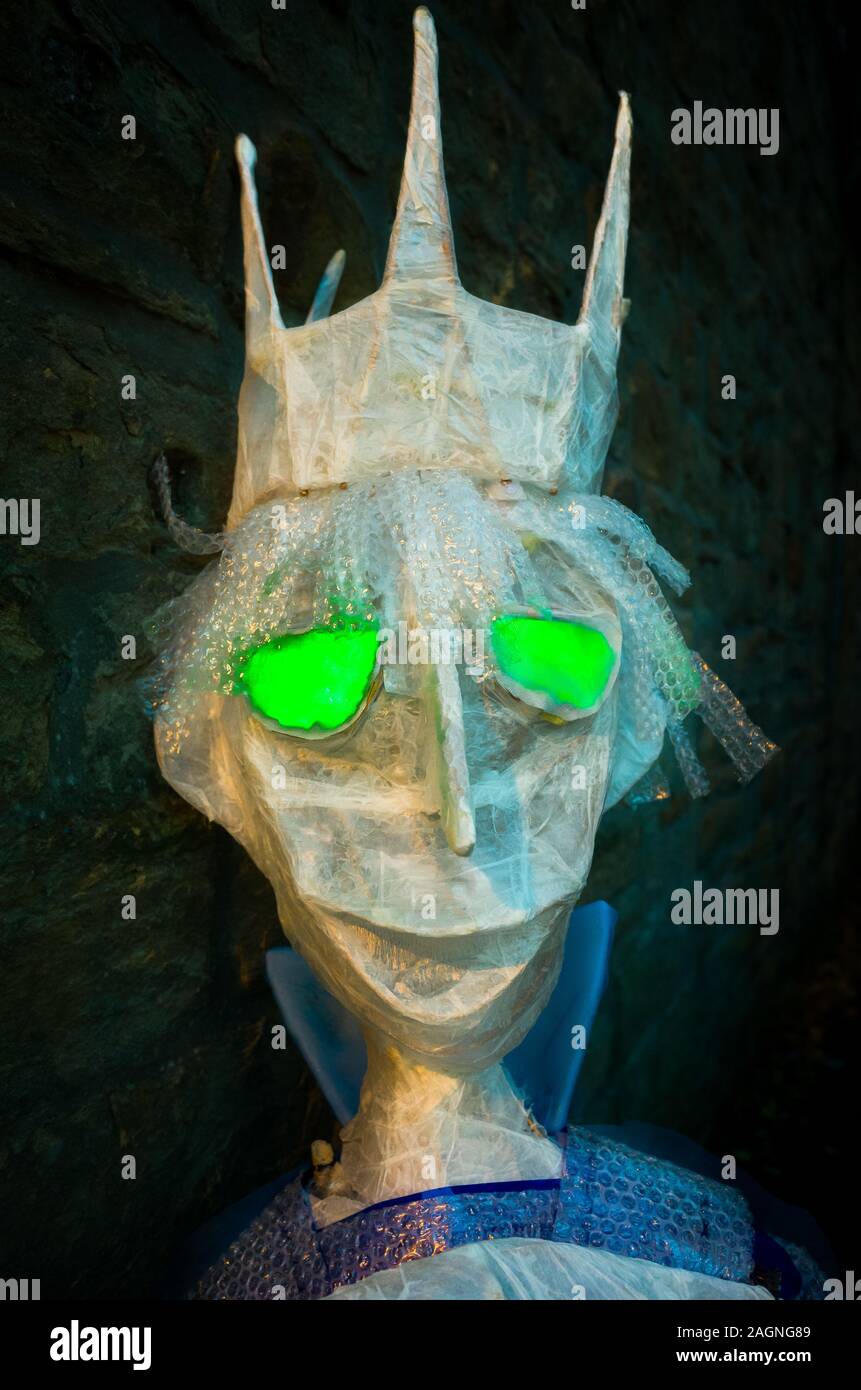 Un spooky re figura in plastica con incandescente gli occhi verdi Foto Stock