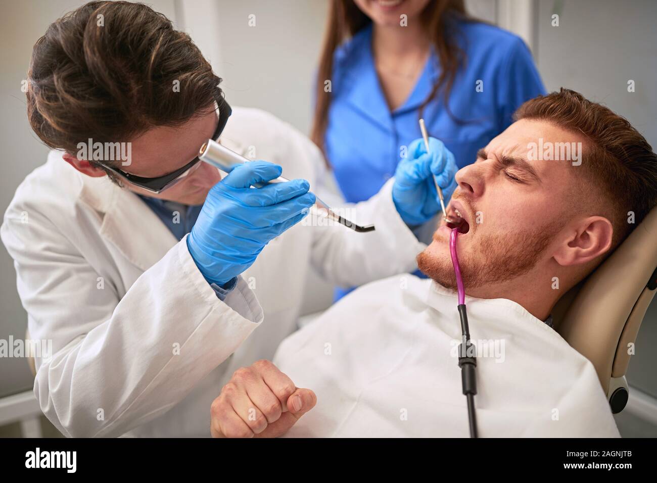 Paziente di sesso maschile al dentista nel riunito dentale avente il mal di denti Foto Stock