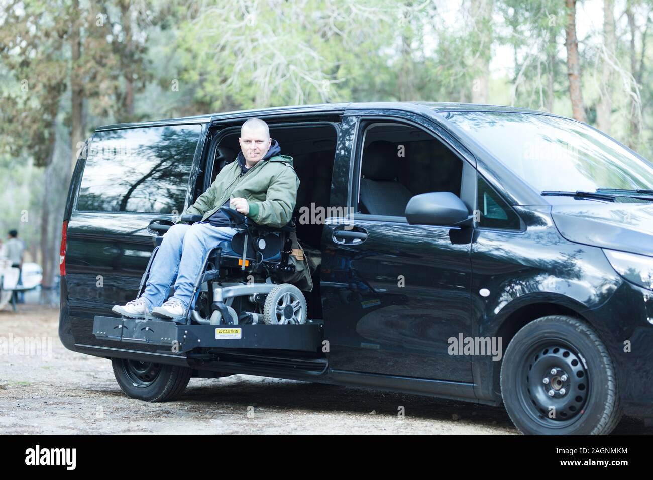 Uomo disabili su sedia a rotelle in piedi sull'ascensore per auto Foto Stock