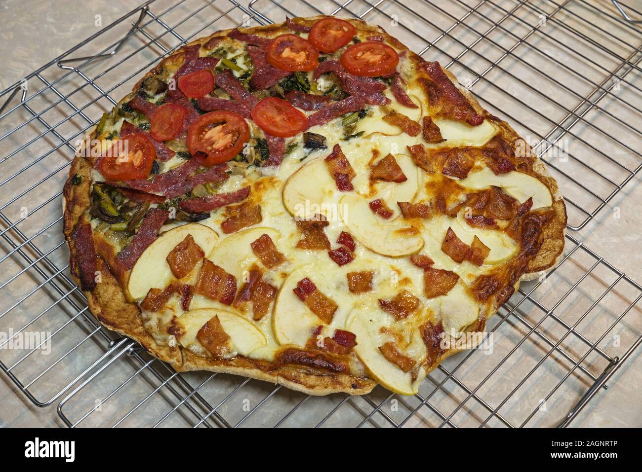 In casa apple la pancetta e il salame vegetale pizza raffreddamento su rack di asciugatura Foto Stock