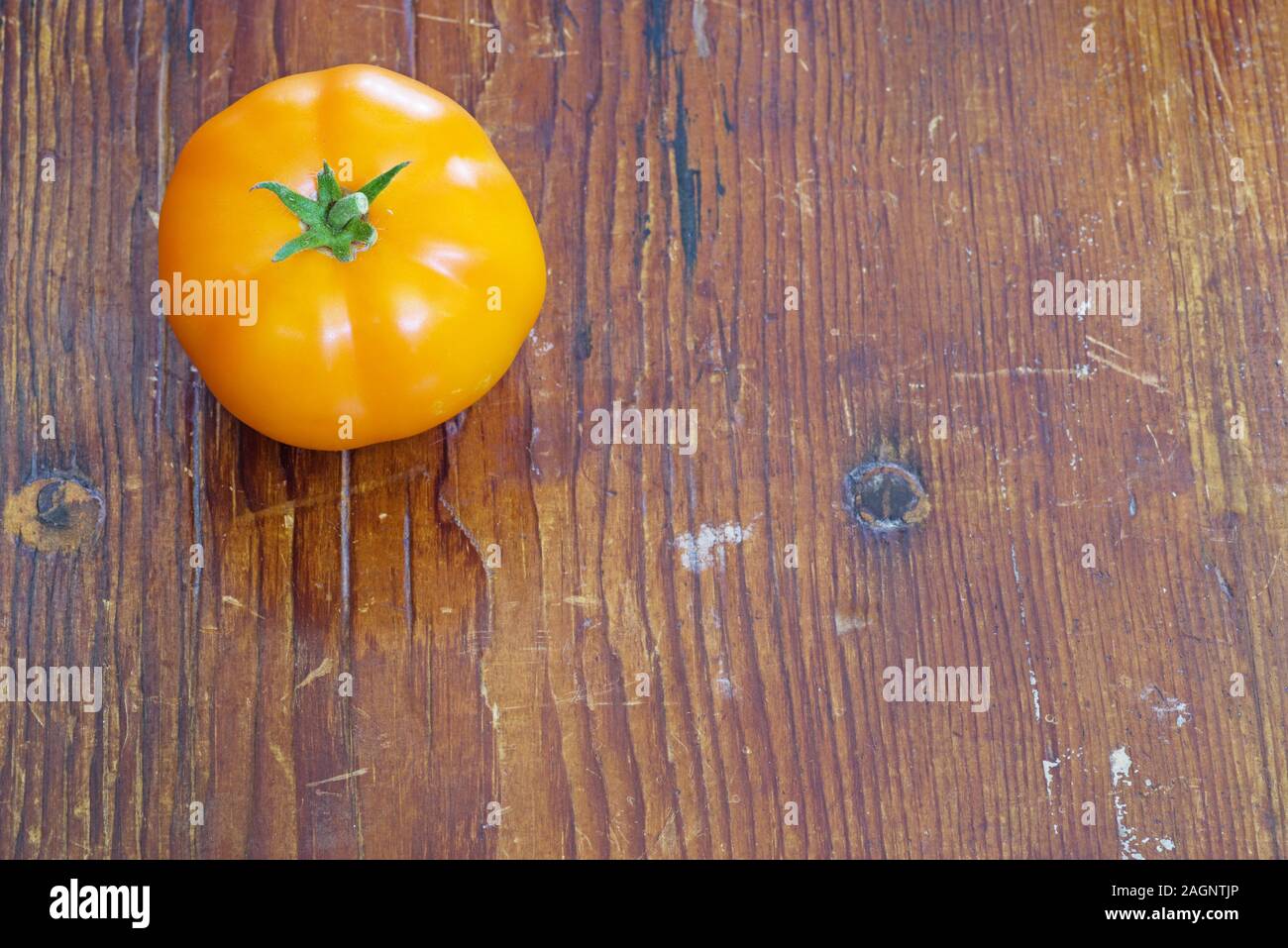 Orange home pomodoro coltivate sul vecchio addolorato Sfondo legno Foto Stock