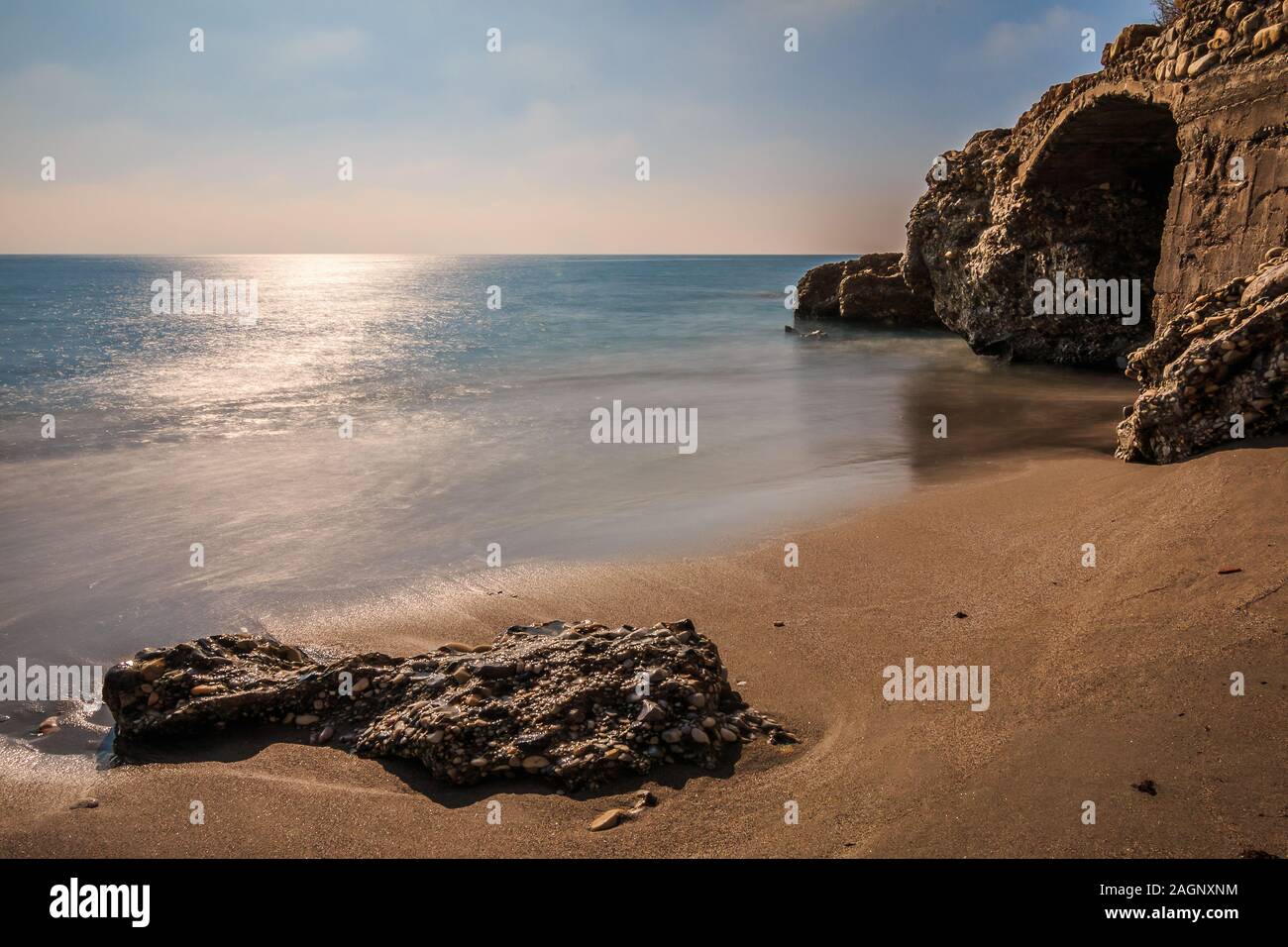 Spiaggia sulla costa mediterranea in Nerja. Spiaggia di sabbia sulla costa spagnola di Costa del Sol. La pietra in spiaggia di sabbia con rocce e arco in pietra Foto Stock